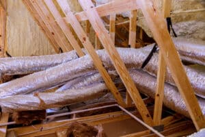 Exposed ductwork wooden beams in renovated attic showcase insulation structural features, AC to run all day.